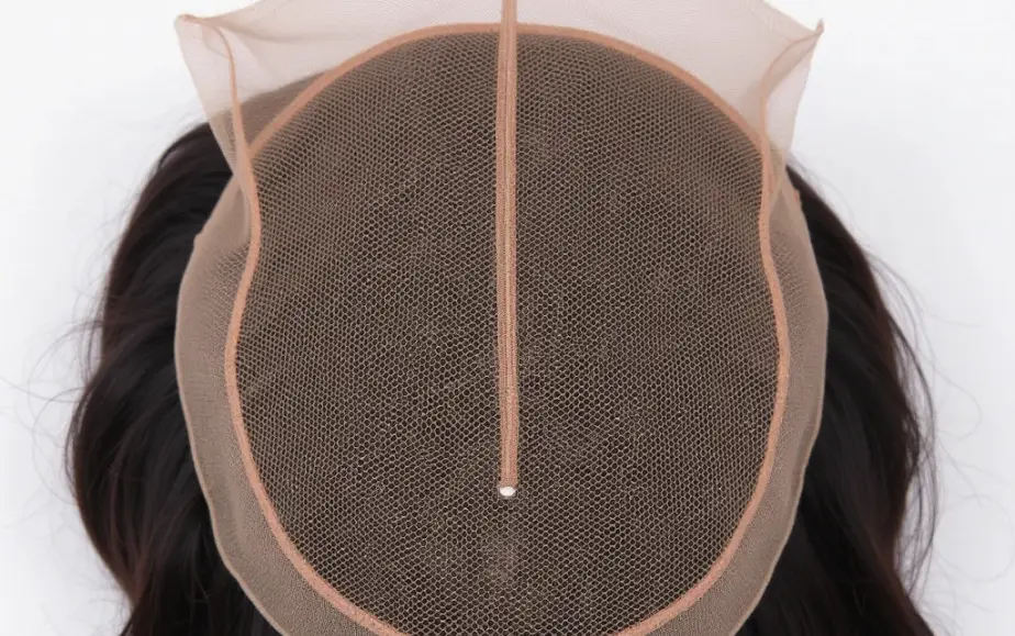 Close-up of a lace hair system base, showing the fine breathable mesh that hair is hand-tied into