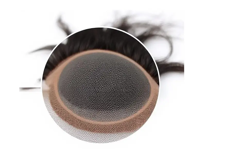 Close-up of a monofilament hair system base, showing the fine mesh that mimics scalp at the parting