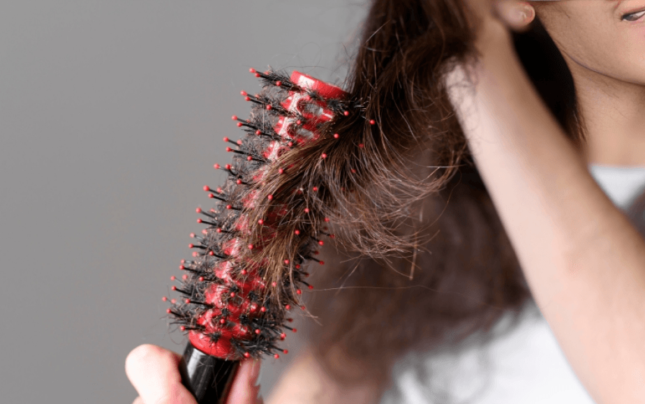 Person brushing hair caught in bristles