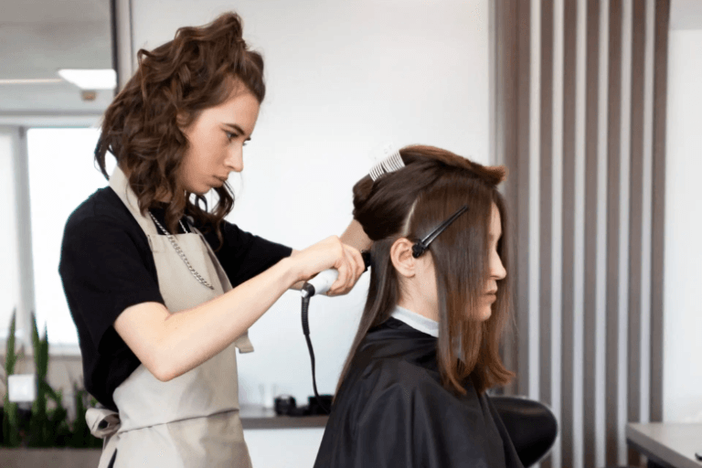 Professional hairstylist styling a hair system in salon.